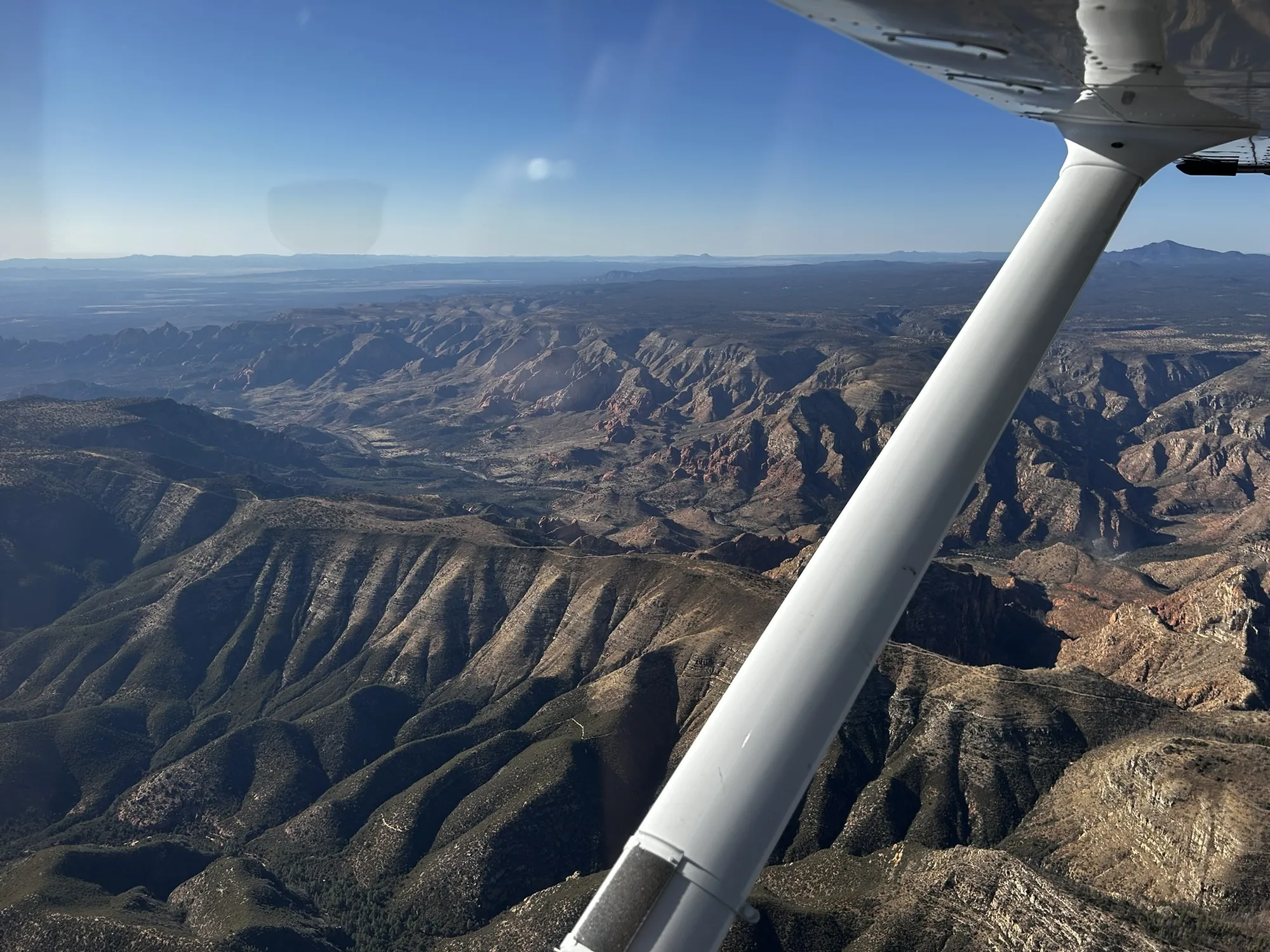 Arizona terrain beneath an aircraft wing